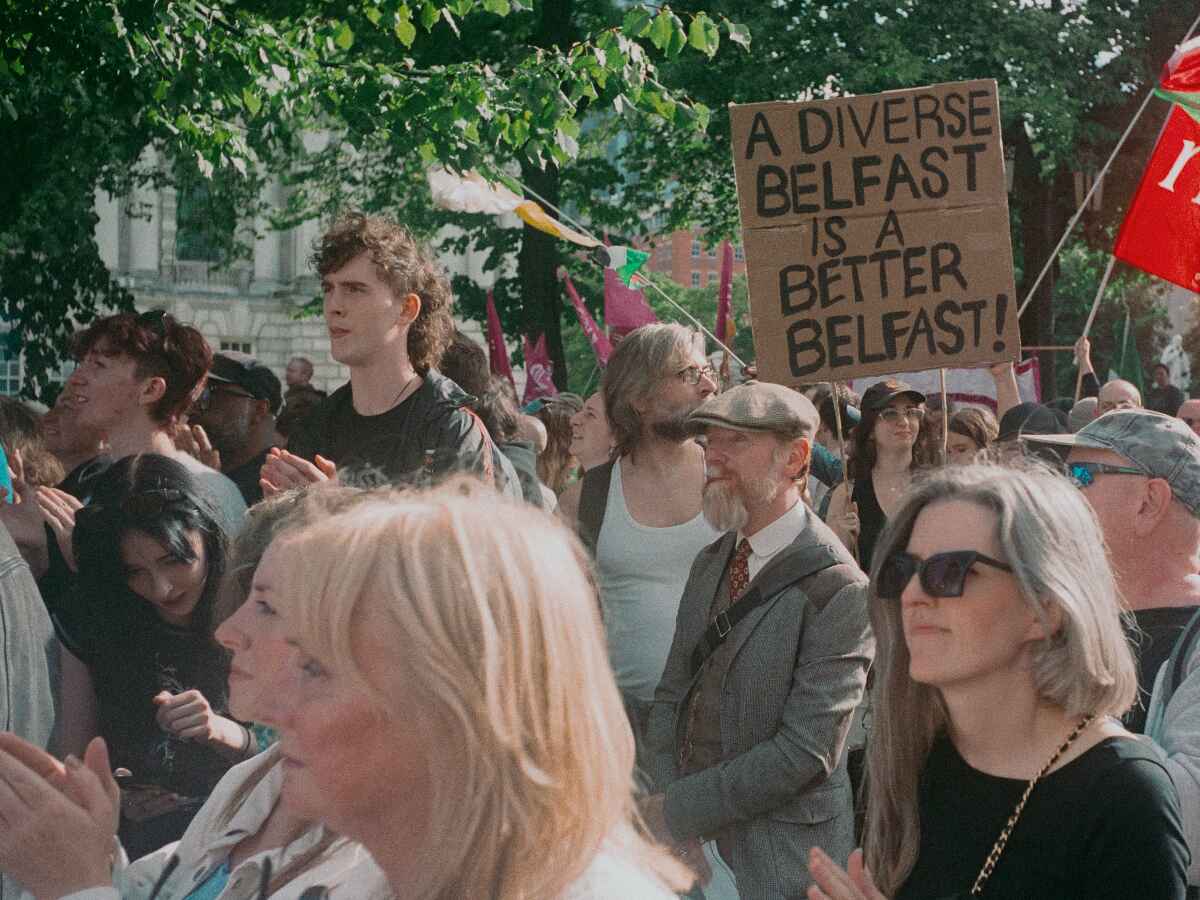 A protester holding a sign saying 'A diverse Belfast is a better Belfast'